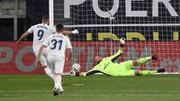 Pemain Real Madrid Karim Benzema (kiri) mencetak gol lewat tendangan penalti ke gawang Cadiz yang dijaga kiper Jeremias Ledesma pada pertandingan La Liga Spanyol di Stadion Ramon Carranza, Cadiz, Spanyol, Rabu  (21/4/2021). Real Madrid menang 3-0. (AP Photo/Jose Breton)