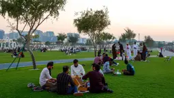 Tradisi ini tidak hanya sekadar penanda waktu, tetapi juga menjadi hiburan dan atraksi budaya yang dinantikan oleh anak-anak dan masyarakat setempat. Tampak dalam foto, orang-orang menyantap hidangan buka puasa (iftar) di Pelabuhan Doha Lama, Qatar selama bulan suci Ramadan 1447 Hijriah pada Kamis 24 Februari 2026. (Karim JAAFAR/AFP)