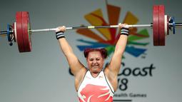 Emily Campbell dari Inggris menangkat beban saat berkompetisi dalam clean and jerk angkat besi + 90kg selama Commonwealth Games 2018 di Carrara Sports Arena di Gold Coast, Australia (9/4). (AP Photo / Mark Schiefelbein)