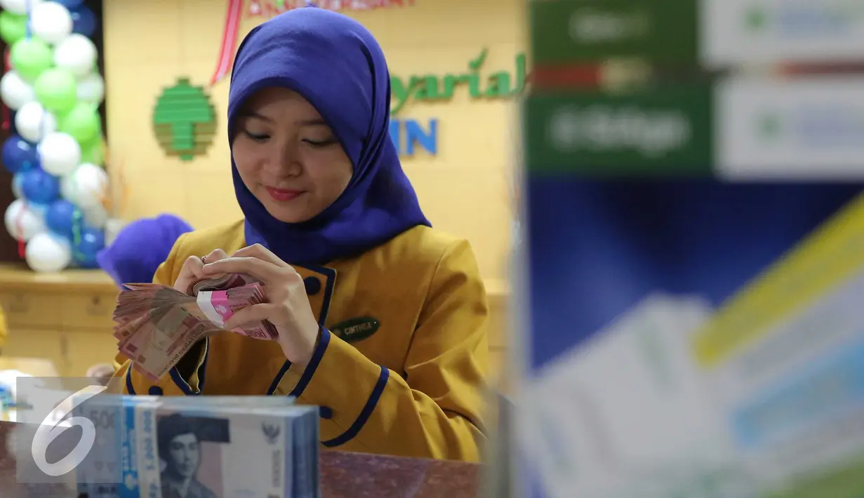 Petugas Bank menghitung uang pecahan Rp100.000 di Bank Bukopin Syariah, Jakarta, Selasa (29/12). Namun kurs tengah Bank Indonesia mencatat rupiah menguat tipis 0,003% ke Rp 13.639 per dollar AS. (Liputan6.com/Angga Yuniar)