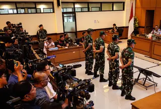 Empat personel Tentara Nasional Indonesia (TNI) yang dituduh menyiram air keras ke seorang aktivis Hak Asasi Manusia (HAM) saat menghadiri sidang pembacaan putusan di Pengadilan Militer II-08, Jakarta pada Rabu 10 Juni 2026. (Yasuyoshi Chiba/AFP)