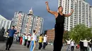 Para peserta Jiamusi Happy Dancing melakukan serangkaian gerakan yang tidak biasa, mulai dari melenggak-lenggok dengan membusungkan dada hingga memutar-mutar lengan mereka. (Jade GAO / AFP)