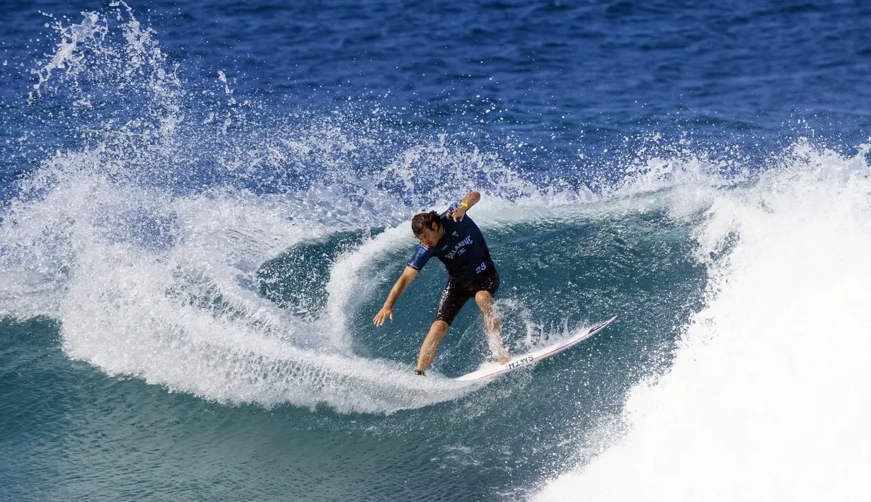 Peselancar Afrika Selatan Jordy Smith mengendarai ombak pada hari pertama Billabong Pipeline Pro di Banzai Pipeline di pantai utara Oahu, Hawaii, pada 1 Februari 2023. Kejuaraan ini berlangsung dari 29 Januari hingga 10 Februari 2023. (AFP/Brian Bielmann)