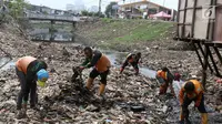 Petugas membersihkan sampah yang memenuhi aliran Kali Gendong di kawasan Penjaringan, Jakarta, Senin (3/12). Penumpukan sampah diperparah dengan perilaku warga yang membuang sampah sembarangan. (Liputan6.com/Immanuel Antonius)