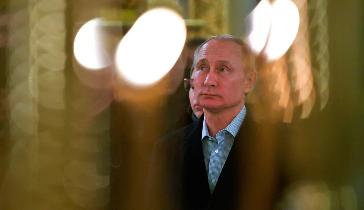 Presiden Rusia Vladimir Putin memanjatkan doa saat mengikuti perayaan Hari Epifani, di biara Nilov dekat danau Seliger, Rusia, 19/1). (Alexei Druzhinin, Sputnik, Kremlin Pool Photo via AP)
