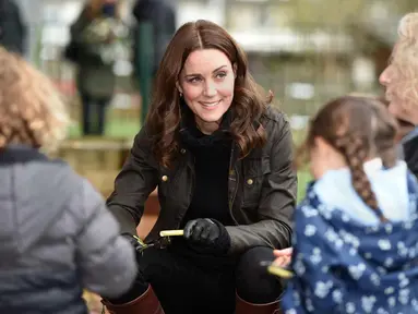 Kate Middleton berbincang dengan anak-anak saat mengunjungi Sekolah Dasar Robin Hood di London, Inggris (29/11). Kedatangan Kate Middleton untuk merayakan sepuluh tahun Kampanye The Royal Horticultural Society (RHS). (AFP Photo/Pool/Eddie Mulholland)