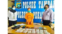 Tersangka narkoba dan barang bukti 16 paket sabu di Polsek Tampan, Pekanbaru. (Liputan6.com/M Syukur)