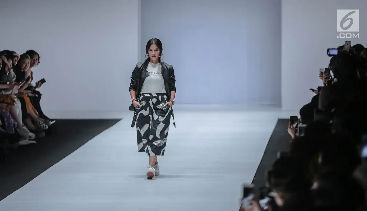 Aktris Dian Sastrowardoyo memperagakan busana bertajuk Cotton Ink x Dian Sastro pada Jakarta Fashion Week 2019 hari ke-5 di Senayan City, Rabu (24/10). "COTTONINK" mempersembahkan sejumlah rancangan dari beberapa artis. (Liputan6.com/Faizal Fanani)