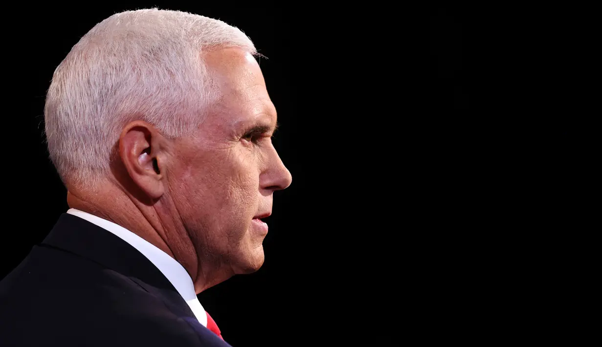 Wakil Presiden Mike Pence menyimak penantangnya, Senator Kamala Harris dari Partai Demokrat berbicara pada Debat cawapres Amerika Serikat di Kingsbury Hall, Universitas Utah di Salt Lake City, Rabu (7/10/2020).  Dalam debat, Pence dan Harris duduk dan diberi sekat kaca. (Justin Sullivan/Pool via AP)