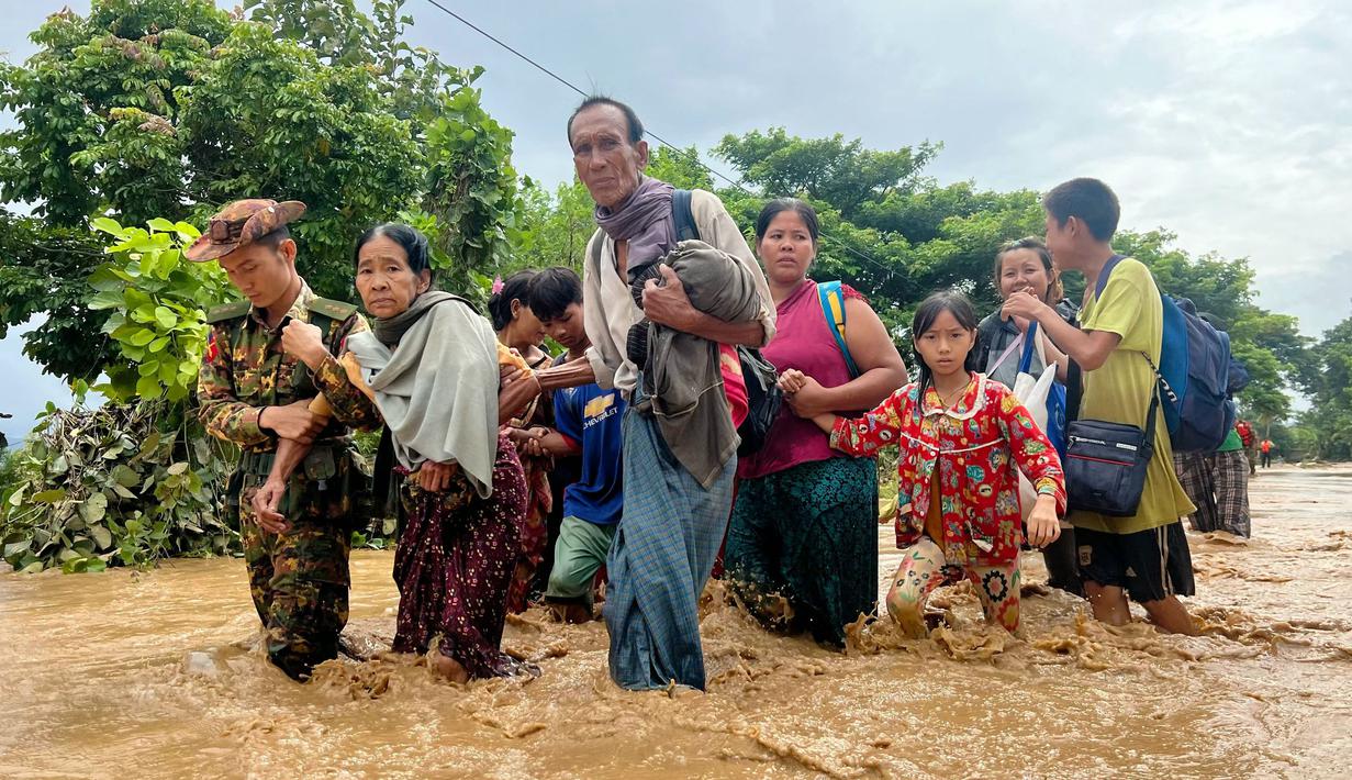 Warga berjalan melintasi banjir di Pyinmana di wilayah Naypyidaw, Myanmar, pada tanggal 13 September 2024. (Sai Aung MAIN/AFP)