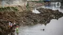 Anak-anak bermain di Sungai Ciliwung yang surut di kawasan Bukit Duri, Jakarta, Sabtu (8/8/2020). Penyusutan debit air Sungai Ciliwung tersebut karena memasuki masa kemarau 2020 yang menurut BMKG akan mencapai puncaknya pada Agustus. (Liputan6.com/Faizal Fanani)