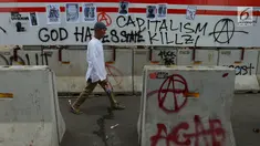 Pejalan kaki melintas dekat aksi vandalisme yang mewarnai Hari Buruh Internasional atau May Day di kawasan Bundaran HI, Jakarta, Rabu (1/5/2019). Belum diketahui siapa yang melakukan aksi corat coret di fasilitas publik tersebut. (merdeka.com/Imam Buhori)