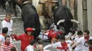 Beberapa peserta terjatuh dan terinjak oleh banteng yang berlari di Festival San Fermin di Pamplona, Spanyol (10/07/2014) (AFP PHOTO/Ander GILLENEA)