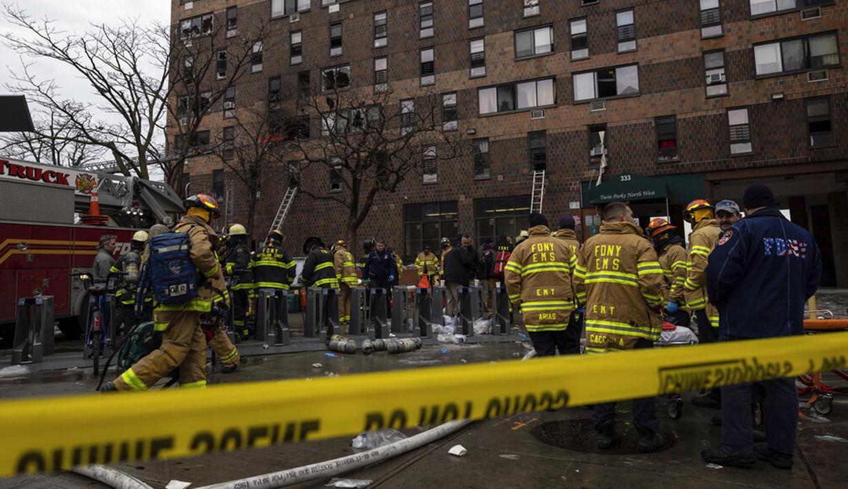Petugas darurat bekerja di lokasi kebakaran gedung apartemen di Bronx, New York, Amerika Serikat, 9 Januari 2022. Sebanyak 19 orang tewas dalam kebakaran maut tersebut. (AP Photo/Yuki Iwamura)