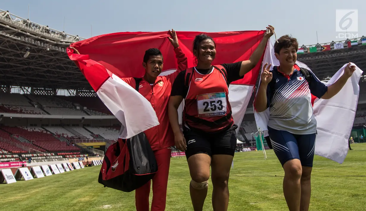 Atlet tolak peluru Indonesia, Suparniyati (tengah) bersama Tiwa (kiri) melakukan selebrasi usai meraih medali emas dan perak Asian Para Games 2018 di Jakarta, Senin (8/10). Suparniyati mencatat tolakan sejauh 10,75 meter. (Bola.com/Vitalis Yogi Trisna)