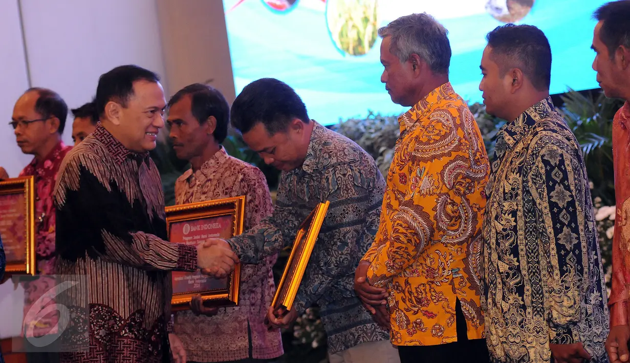 Gubernur Bank Indonesia, Agus DW Martowardojo (kiri) memberikan penghargaan program pengendalian inflasi 2016 di Jakarta, Senin (25/4/2016). 13 klaster dinilai sukses mengembangkan program pengendalian inflasi. (Liputan6.com/Helmi Fithransyah)