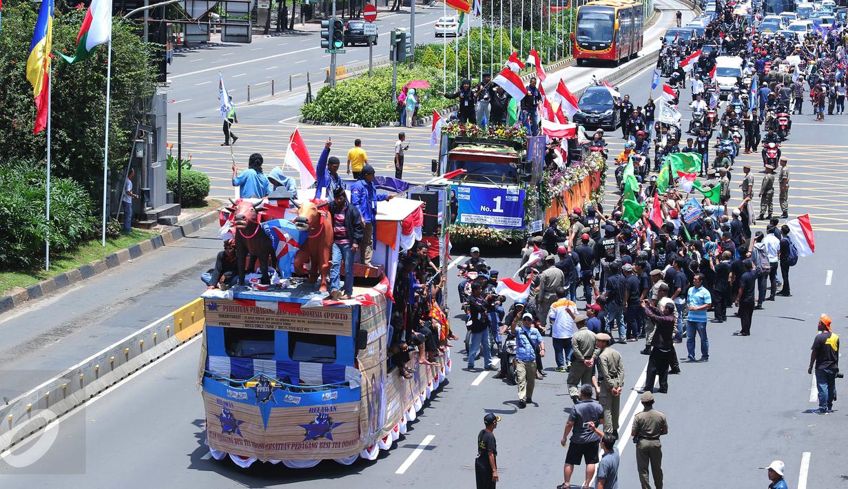 Iring-iringan mobil karnaval para pasangan Cagub DKI Jakarta saat melintas di Thamrin, Jakarta, Sabtu (29/10). Selain mekukan karnaval mobil hias, ke tiga pasangan Cagub tersebut juga melakukan deklarasi pilkada damai. (Liputan6.com/Angga Yuniar)