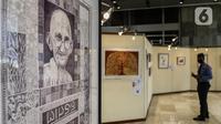 Pengamanan dalam DPR  melihat karya lukis dan karya foto pada pameran 150 Tahun Mahatma Gandhi di kompleks Parlemen, Senayan, Jakarta, Jumat (2/10/2020). Dalam pameran ini juga memperingati 150 tahun hari kelahiran Mahatma Gandhi serta Peringatan Hari Anti Kekerasan Dunia. (Liputan6.com/Johan Tallo)