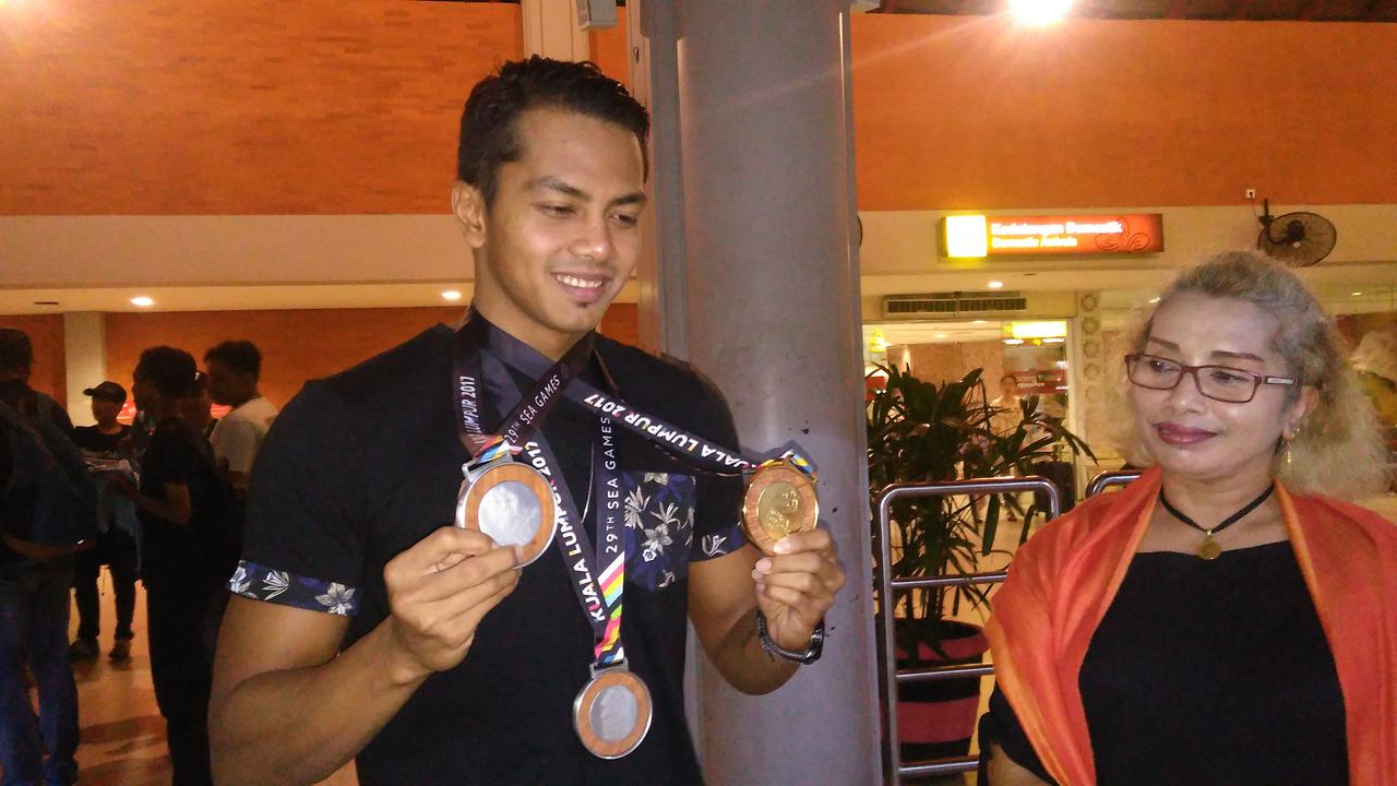 I Gede Siman Sudartawa memamerkan medali SEA Games disaksikan sang ibu, Ni Made Sri Kardini. (Liputan6.com/Dewi Divianta)