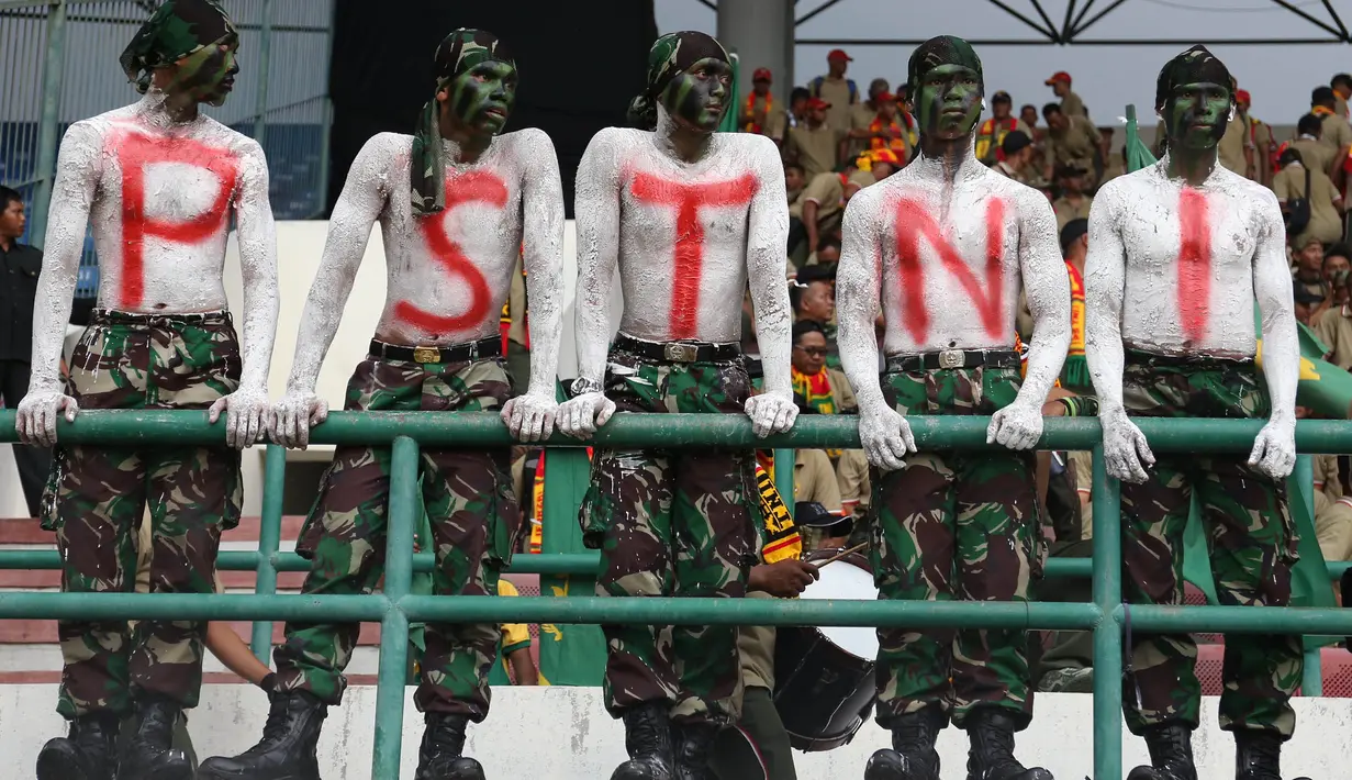 Para suporter PS TNI mewarnai tubuhnya saat mendukung tim kesayangannya berlaga melawan Semen Padang pada laga 8 besar Piala Jenderal Sudirman di Stadion Manahan, Solo, Sabtu (12/12/2015). (Bola.com/Nick Hanoatubun)