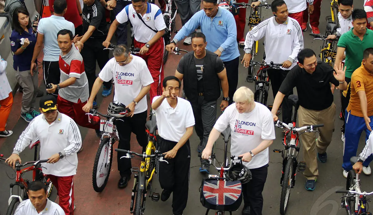 Presiden Joko Widodo (menunjuk) bersepeda bersama Walikota London, Boris Johnson di Jakarta, Minggu (30/11/2014). (Liputan6.com/Faizal Fanani)