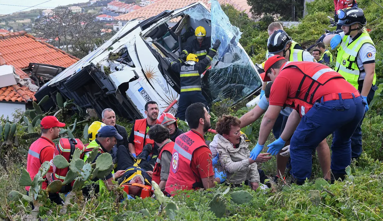 Petugas memberikan pertolongan kepada korban kecelakaan sebuah bus pariwisata di Kota Canico, Pulau Madeira, Portugal, Rabu (17/4). Menurut pejabat perlindungan sipil regional, para turis korban kecelakaan berusia antara 40 hingga 50 tahun. (RUI SILVA / AFP)