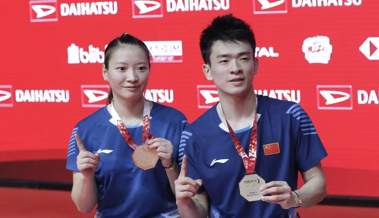 Pasangan Cina, Zheng Siwei/Huang Yaqiong, melakukan selebrasi usai menaklukkan Tontowi Ahmad/Lilyana Natsir, pada laga Indonesia Masters 2019 di Istora, Jakarta, Minggu (27/1). Tontowi/Liliyana kalah 21-19, 19-21, 16-21. (Bola.com/M Iqbal Ichsan)