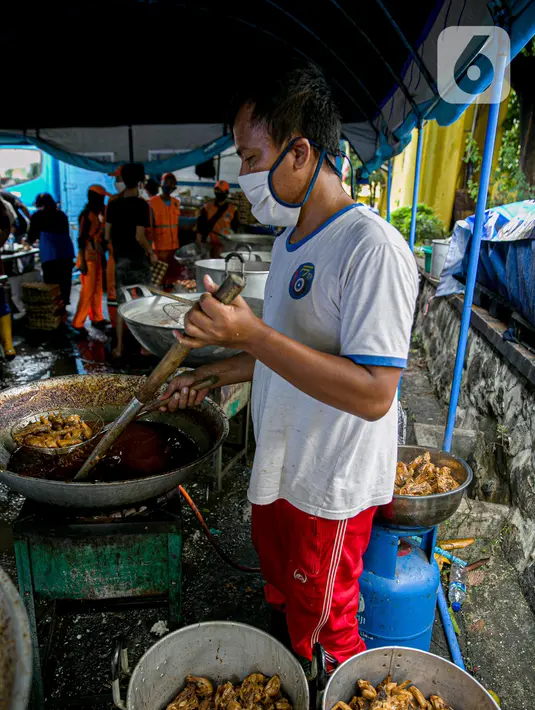 Petugas Taruna Siaga Bencana (Tagana) menggoreng daging ayam di Dapur Umum Kementerian Sosial di GOR Otista, Jakarta, Minggu (21/2/2021). Dalam sehari, petugas menyiapkan hingga 6.000 paket nasi kotak yang didistribusikan ke 11 kelurahan terdampak banjir. (Liputan6.com/Faizal Fanani)