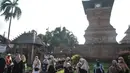 Peziarah bersantai di dekat Menara Kudus, Kauman, Kabupaten Kudus, Jawa Tengah, Rabu (30/3/2022). Menara berusia 473 tahun yang dahulu berfungsi sebagai tempat mengumandangkan azan menjadi lokasi favorit pengunjung untuk bersantai usai berziarah di Makam Sunan Kudus. (merdeka.com/Iqbal S. Nugroho)