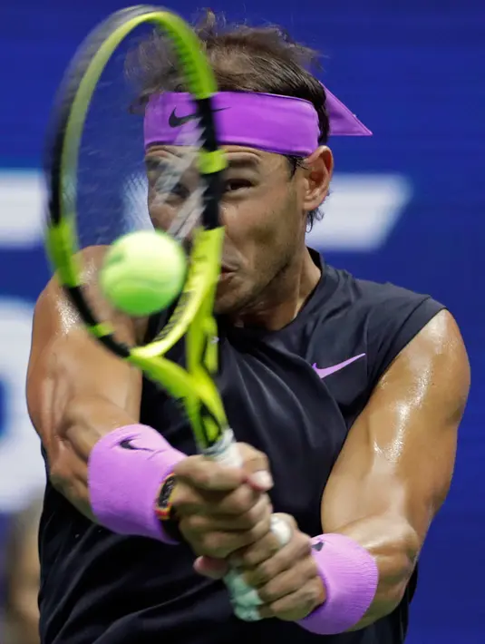 Petenis Spanyol, Rafael Nadal mengembalikan bola ke arah petenis Australia, John Millman pada babak pertama AS Terbuka 2019 di USTA Billie Jean King National Tennis Center, Kamis (27/8/2019). Kemenangan 6-3, 6-2, 6-2 atas Millman mengantar Nadal lolos ke babak kedua. (AP/Adam Hunger)