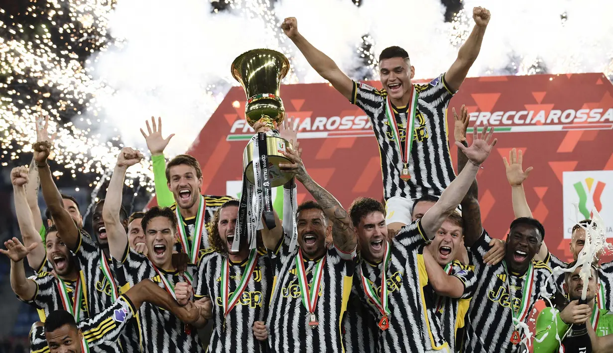 Bek Juventus, Danilo memegang trofi saat para pemain Juventus merayakan kemenangan di Final Piala Italia melawan Atalanta di stadion Olimpico, Roma, 15 Mei 2024. (Filippo MONTEFORTE/AFP)