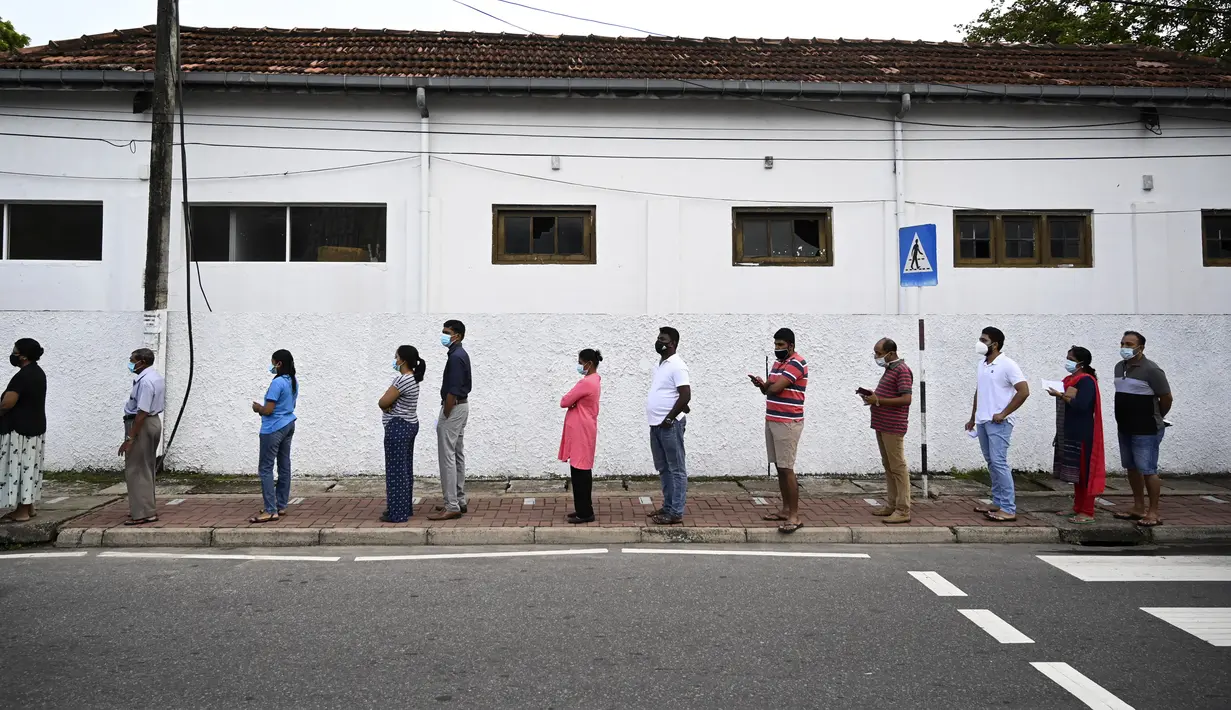 Para pemilih mengenakan masker saat antre di luar tempat pemungutan suara di Kolombo, Sri Lanka, Rabu (5/8/2020). Sri Lanka menggelar pemilihan parlemen di tengah pandemi COVID-19. (Ishara S. KODIKARA/AFP)
