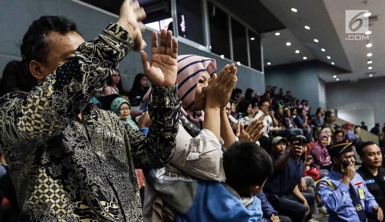 Terpidana kasus dugaan pelanggaran UU ITE sekaligus korban pelecehan seksual Baiq Nuril mengatupkan tangannya saat DPR menyetujui amnesti untuk dirinya dalam rapat paripurna DPR di Kompleks Parlemen Senayan, Jakarta, Kamis (25/7/2019). (Liputan6.com/JohanTallo)