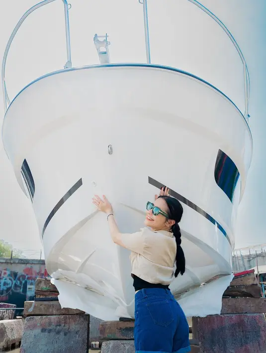 Prilly tampak bergaya kasual di samping yacht barunya. Ia mengenakan atasan kemeja krem dengan celana pendek jeans, menambah kesan santai namun stylish. Tak tanggung-tanggung, harga kapal ini disebut mencapai Rp2,5 miliar. (Liputan6.com/IG/@prillylatuconsina96)