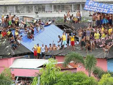 Ratusan Narapidana berkumpul di atap penjara saat unjuk rasa menuntut penggantian kepala penjara di Manila City Jail, Filipina (13/10). Para narapidana mengelar aksi nekat dengan menaiki atap penjara dan membentangkan spanduk protes. (REUTERS/Stringer)