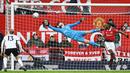 Kiper Manchester United, David de Gea, berusaha menghalau bola saat melawan Fulham pada laga Liga Inggris di Stadion Old Trafford (19/3/2023). (AFP/Paul Ellis)