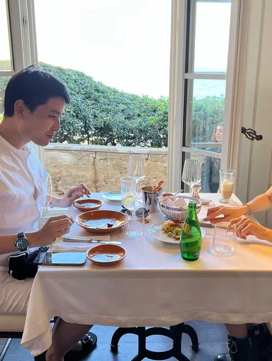 Makan bersama, kedua tampil serasi dengan busana warna putih. Nong Poy tampil dengan dress sleeveless dan boots hitam.  [@poydtreechada]