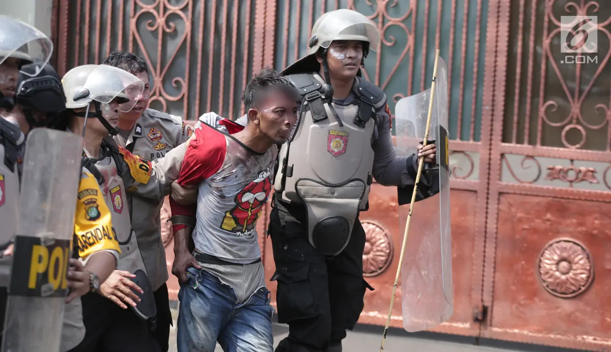 Polisi menangkap seorang pria saat tarjadi bentrok dengan massa di kawasan Petamburan, Jakarta Barat, Rabu (22/5/2019). Kapolres Metro Jakarta Barat Kombes Hengki Haryadi menduga kuat massa aksi yang diamankan bukan merupakan warga Jakarta. (Liputan6.com/Faizal Fanani)