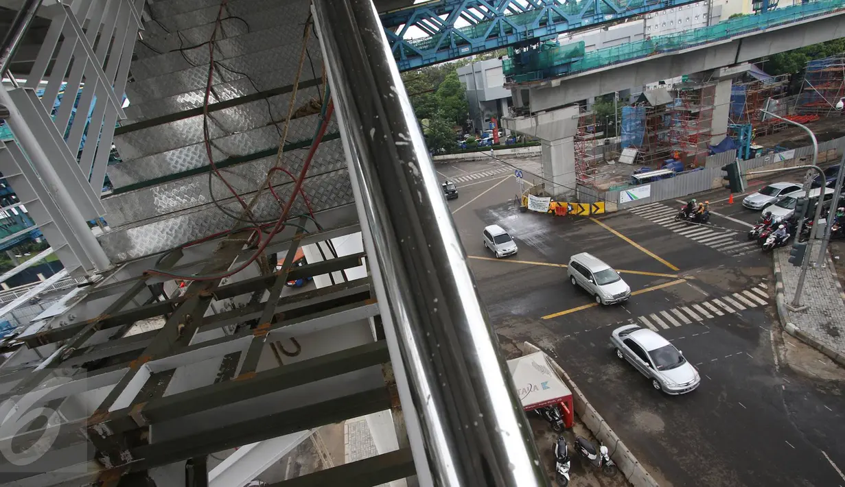 Sejumlah kendaraan melintas di bawah  pembangunan Jembatan Penyeberangan Orang (JPO) halte layangTransjakarta CSW di Kebayoran Baru, Jakarta, Senin (9/1). JPO halte ini setara dengan bangunan empat lantai. (Liputan6.com/Immanuel Antonius)