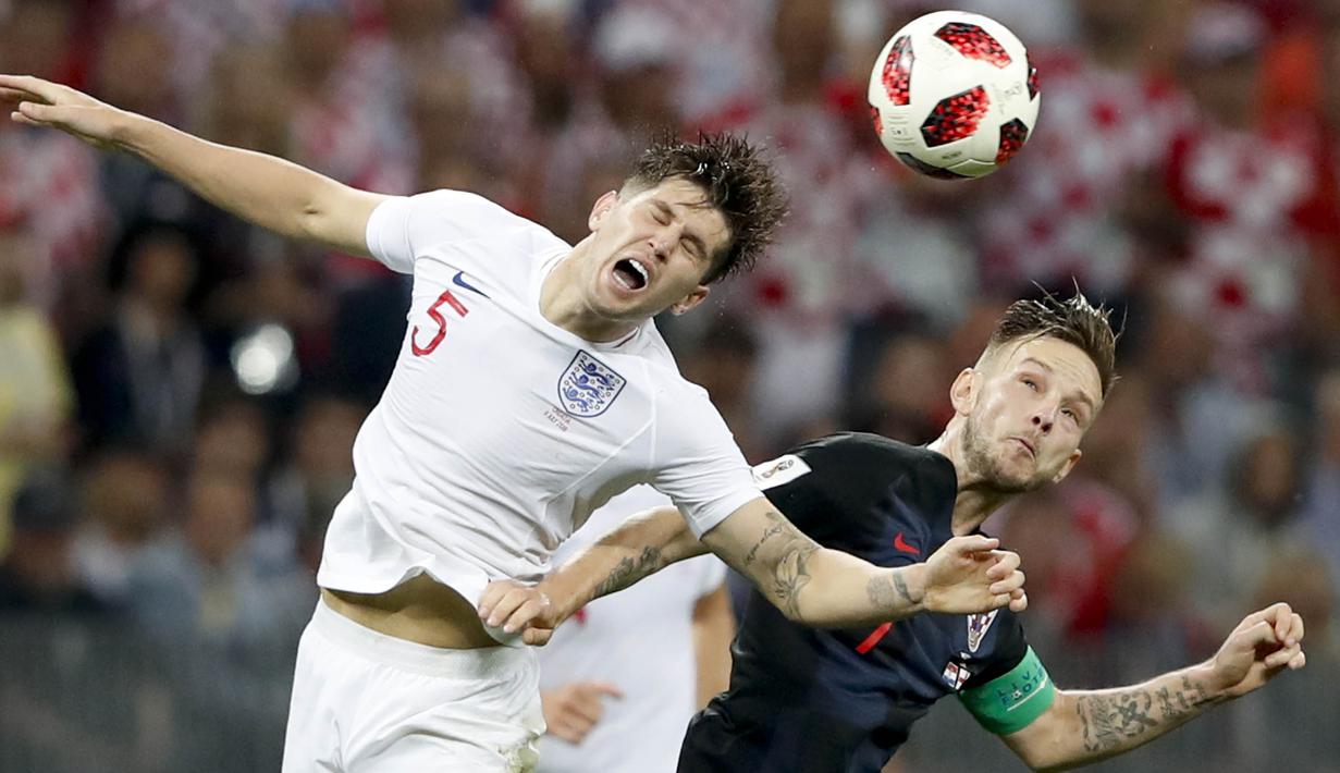 Gelandang Kroasia, Ivan Rakitic, duel udara dengan bek Inggris, John Stones, pada laga semifinal Piala Dunia di Stadion Luzhniki, Rabu (11/7/2018). Kroasia menang 2-1 atas Inggris. (AP/Rebecca Blackwell)