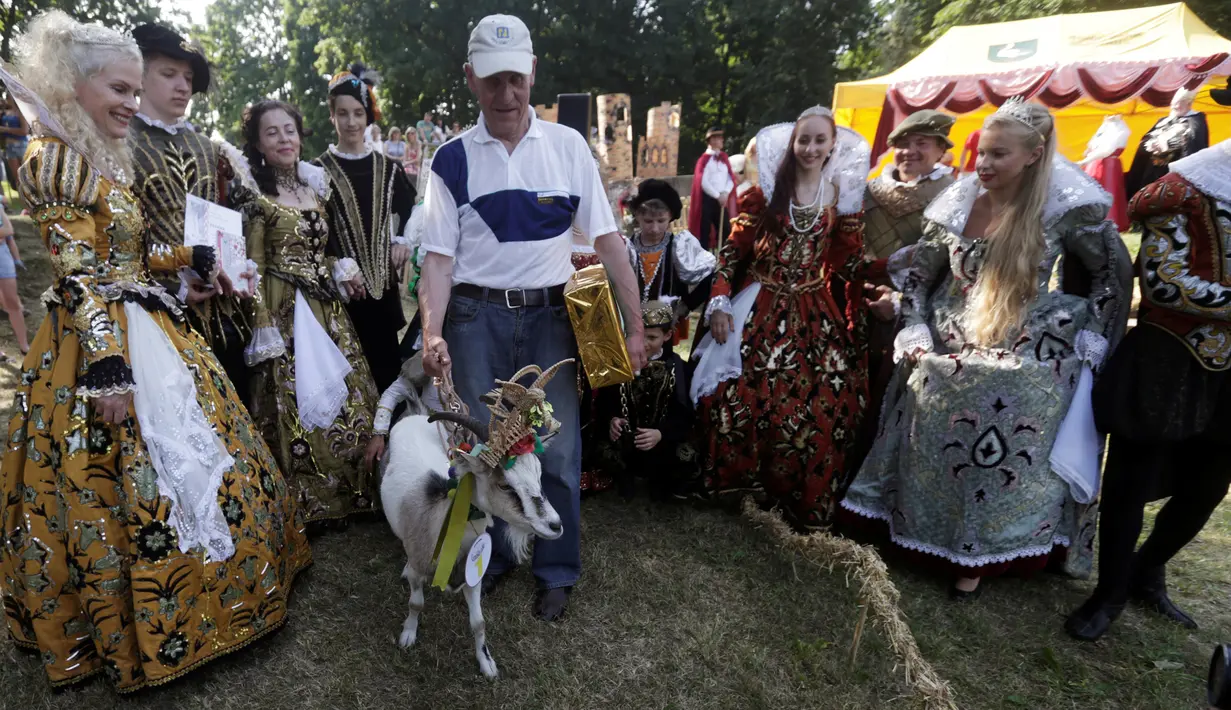 Ferdinandas Petkevicius berpose dengan kambingnya, Demyte, yang menjadi pemenang kontes kecantikan kambing di Ramygala, Lithuania, Minggu (26/6). Kontes kecantikan unik yang melibatkan kambing ini merupakan tradisi turun temurun. (REUTERS/Ints Kalnins)