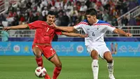 Aksi bek Thailand, Elias Dolah (kanan) saat membayangi pemain Oman, Issam al-Sabhi dalam laga Piala Asia 2023. (HECTOR RETAMAL / AFP)