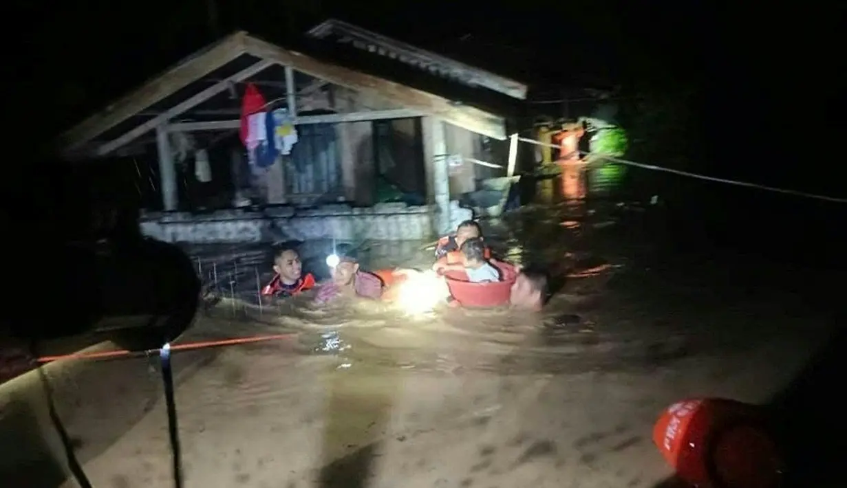 Penyelamat mengevakuasi orang-orang dari daerah banjir di Kota Ozamiz, Misamis Occidental, Filipina (25/12/2022). Dua orang tewas dan hampir 46.000 lainnya meninggalkan rumah mereka saat banjir pada libur Hari Natal. (Handout / Philippine Coast Guard (PCG) / AFP)