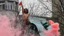 Seorang aktivis wanita gerakan hak perempuan Femen meneriakkan slogan-slogan di tiang monumen Soviet di pusat kota Kiev, Ukraina (7/11). Aktivis tersebut menggelar aksi memperingati 100 tahun Revolusi Bolshevik. (AFP Photo/Genya Savilov)