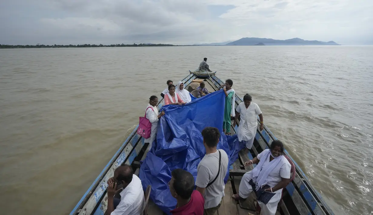 Saat persalinannya berlangsung, tim di atas perahu dengan cepat mulai bekerja, mengangkat terpal untuk melindungi dari hujan saat mereka membantu persalinan. (AP Photo/Anupam Nath)