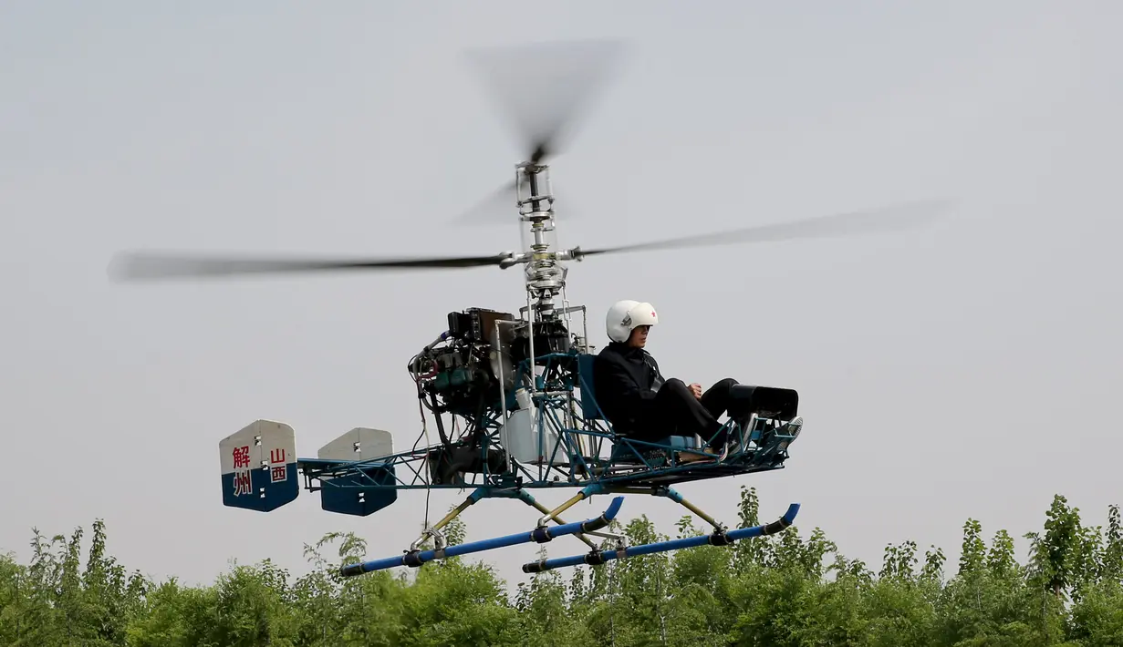 Pria 60 tahun bernama Guo Leiting saat terbang menggunakan helikopter buatannya sendiri di Yuncheng , provinsi Shanxi , Cina, 21 April 2016. Meskipun tinggal di desa dengan bahan seadanya, Ia mampu membuat helikopter. (REUTERS / Stringer)