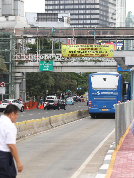 Spanduk sosialisasi pembongkaran JPO Tosari terpasang di Jalan Jenderal Sudirman, Jakarta, Jumat (14/12). Penggunaan pelican crossing di kawasan ini menggantikan fungsi JPO Tosari yang akan dibongkar. (Liputan6.com/Helmi Fithriansyah)
