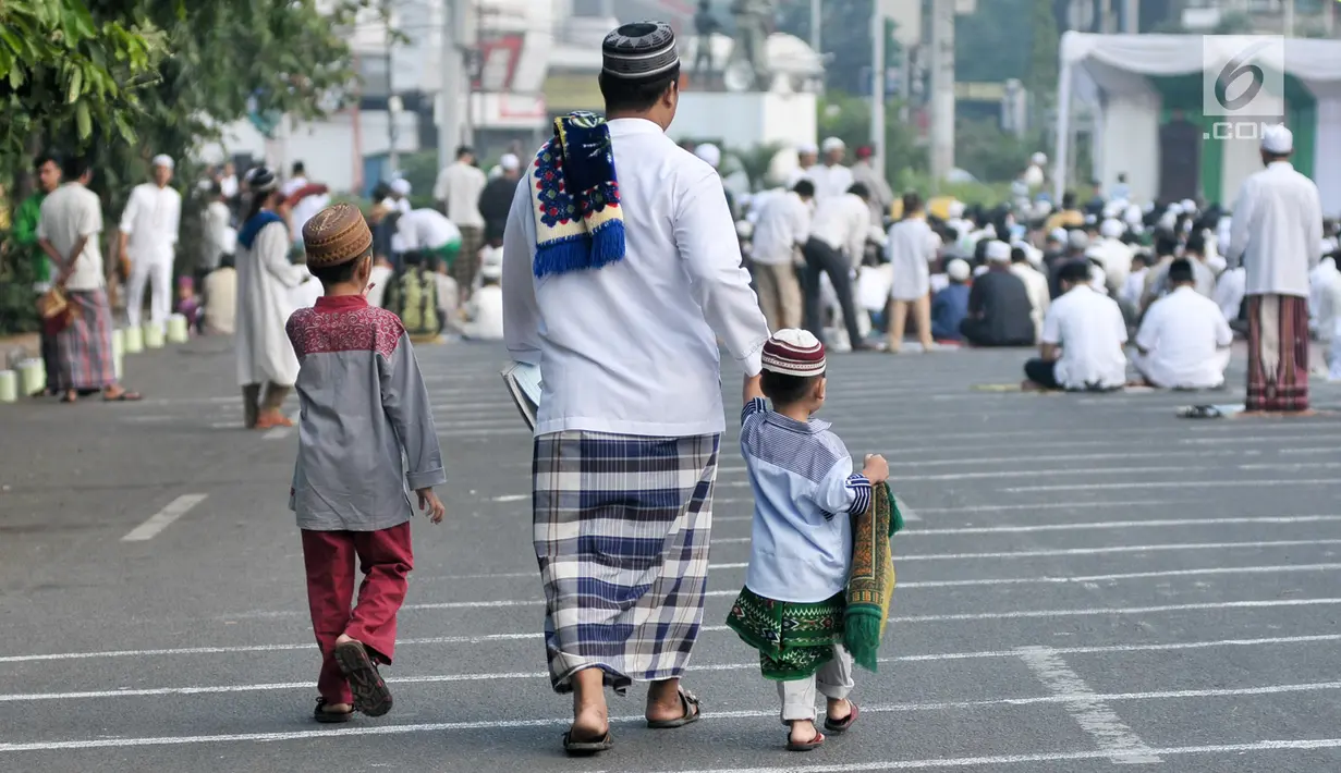 Seorang pria bersama dua orang anak berjalan menuju tempat pelaksanaan salat Idul Fitri 1438 H di kawasan Jatinegara, Jakarta, Minggu (25/7). Ruas Jalan Jatinegara Barat disulap menjadi tempat pelaksanaan salat Ied. (Liputan6.com/Yoppy Renato)