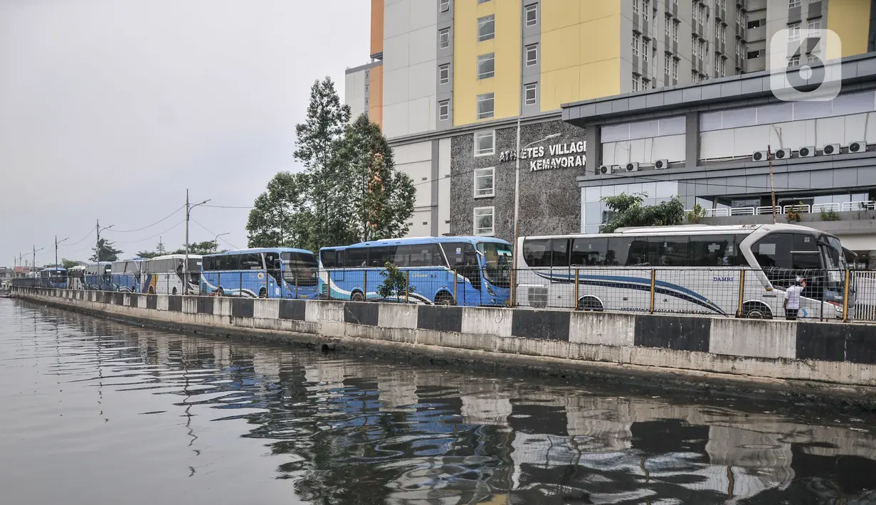 Bus yang mengangkut TKI dari luar negeri mengantre masuk untuk menjalani karantina di RSDC Wisma Atlet Kemayoran, Jakarta, Kamis (16/12/2021). Menkes Budi Gunadi Sadikin mengumumkan temuan kasus varian Omicron dari pekerja kebersihan di RSDC Wisma Atlet Kemayoran. (merdeka.com/Iqbal S. Nugroho)