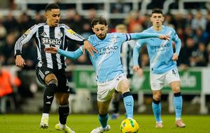 Bruno Guimaraes berlari membawa bola melewati Phil Foden dalam laga leg pertama semifinal Piala Liga Inggris antara Newcastle vs Manchester City di St. James' Park, 14 Januari 2026. (AP Photo/Dave Thompson)